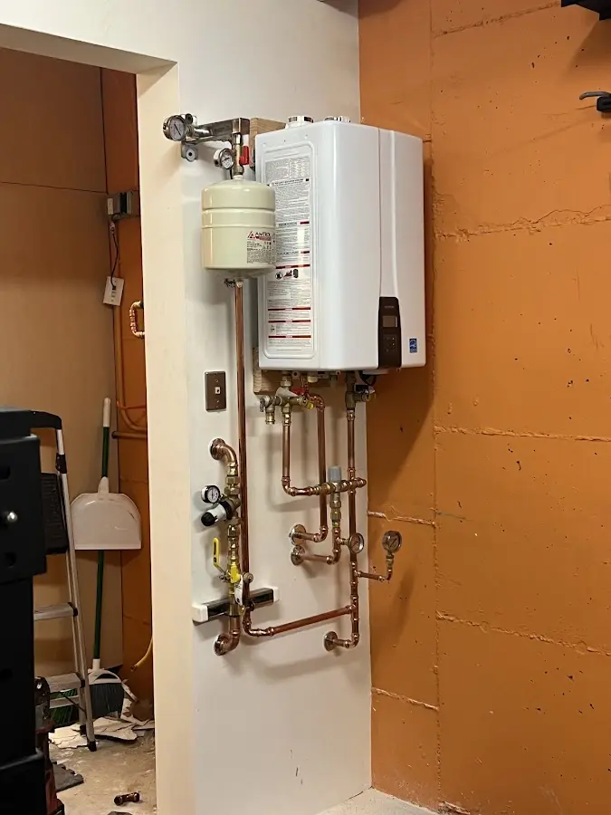 Plumbing technician inspecting water heater connections in Brushy Creek